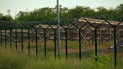 Solar Panels are Located in a Field Behind a Barbed Wire Fence Stock Footage 198477115
