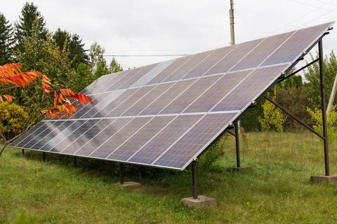 Solar panels are positioned at an angle in a green field, effectively captu.. Stock-Fotos