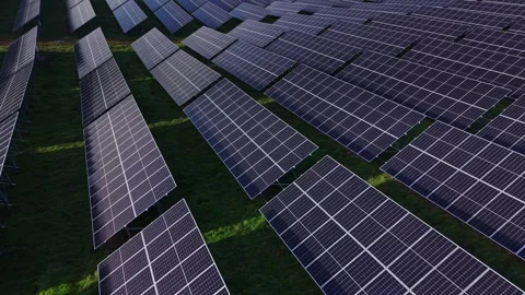 Solar panels arranged in rows capture sunlight in a green field 库存影片 329999447