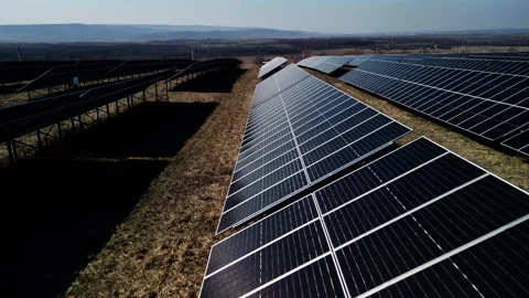 Solar panels arranged in rows capture sunlight on a clear day, showcasing Stock-Footage 336746015