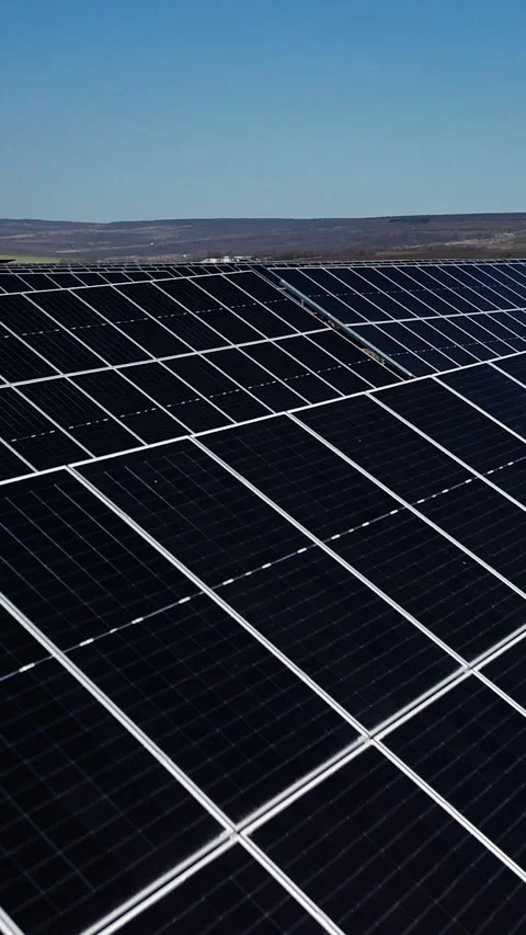 Solar panels arranged in rows capture sunlight on a clear day, showcasing the 動画素材 336948360