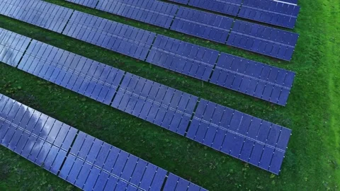 Solar panels arranged in rows on green land in aerial view Stock Footage 325090889