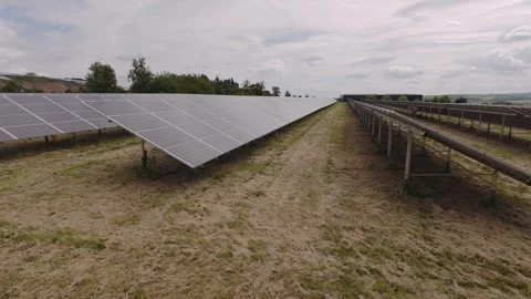 Solar panels array in field under blue sky with scattered clouds Stock Footage 328108234