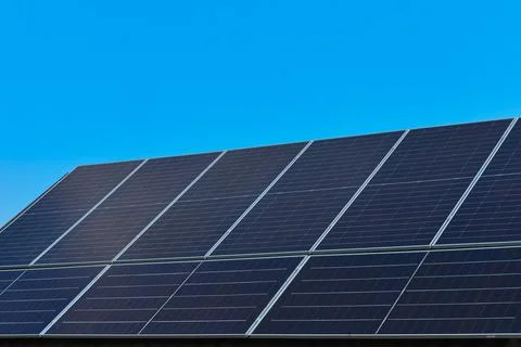 Solar Panels Array Installed Against Clear Blue Sky Stock Photos