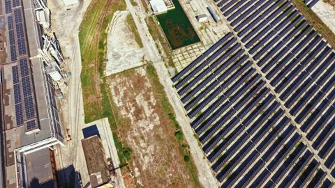 Solar panels array located in an industrial area with a bare patch of land 库存影片 344215438