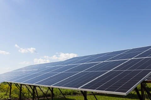 Solar panels on the background of a blue cloudy sky. Solar power plant. Stock Photos