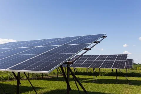 Solar panels on the background of a blue cloudy sky. Solar power plant. Stock Photos
