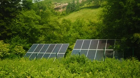 Solar panels basking in sunlight are positioned amidst a vibrant green landscape 動画素材 312632174