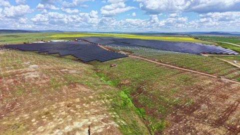 Solar panels being installed in a rural area during daytime under a blue sky Stock Footage 342500226