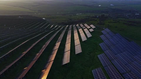 Solar panels capture sunlight on a field during late afternoon Stockbeeldmateriaal 329996487