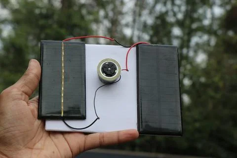 Solar panels connected to dc motor that shows the concept of harnessing Stock Photos