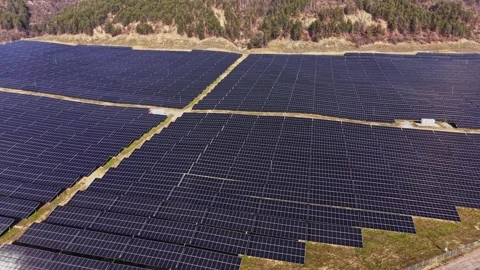 Solar panels cover large area in green landscape during daytime Stock Footage 334032197