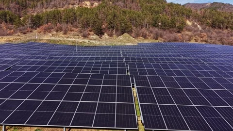 Solar panels cover large area in rural location under clear skies 스톡 동영상 334033056
