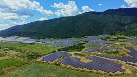 Solar panels cover a large area in a valley surrounded by hills and mountains Stock Footage 341606016