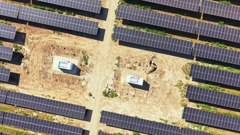 Solar panels cover a large area with two control units in the center on a sunny Stock Footage 342736743