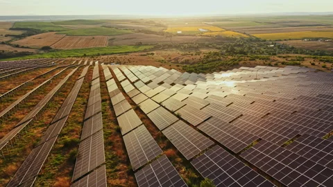 Solar panels cover a large field in a rural area during sunset with fields Stock Footage 340933455