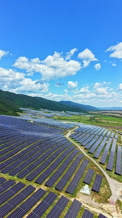 Solar panels cover large fields in a rural area under a bright sky with clouds Stock Footage 340870772