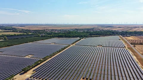 Solar panels cover large fields in a rural area with a clear sky and wind Stock Footage 342745687