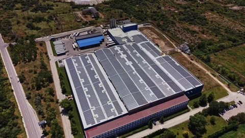 Solar panels cover a large warehouse in a rural setting surrounded by trees Stock Footage 339648920
