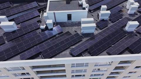 Solar panels cover the rooftop of a building in a city setting Stock Footage 339020546