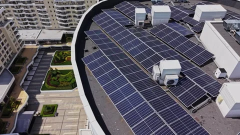 Solar panels cover the rooftop of a building in a city during daytime Stock Footage 339021008