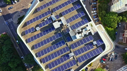 Solar panels cover the rooftop of a building in a city, showing the shift to Stock Footage 340765365