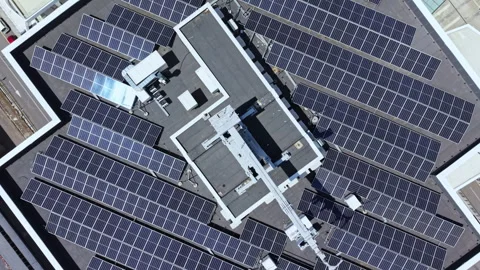 Solar panels cover the rooftop of a large building in an urban area during a Stock Footage 337933719