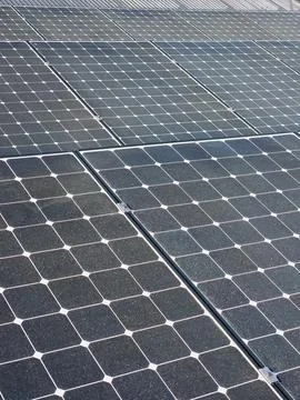 Solar panels cover rooftop with rows of photovoltaic cells and metal roof edg Stock Photos