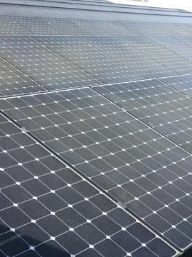 Solar panels cover rooftop surface with rows of photovoltaic modules Stock Photos