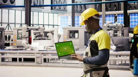 Solar panels factory engineer analyzes performance data with green screen laptop Stock Footage 308725613