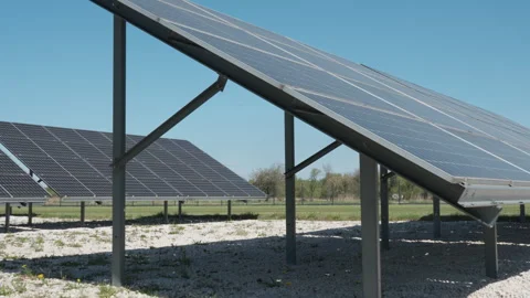 Solar panels on ground-mounted rack generating clean energy under blue sky Stock-Footage 333982324