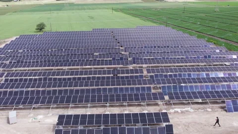 Solar panels installation on ground stands beside grass orbit aerial Stock Footage 332399623