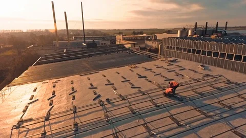 Solar panels installation at sunset. Workers attaching metal basis on roof Stock Footage 125894063