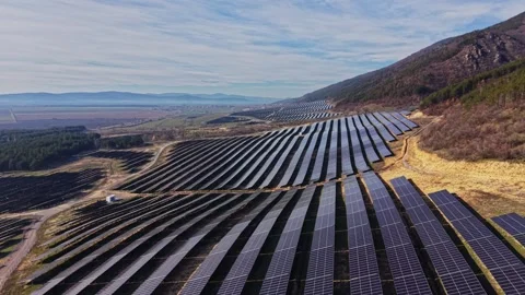 Solar panels installed on a hillside in a rural area during daytime Stock Footage 334032273