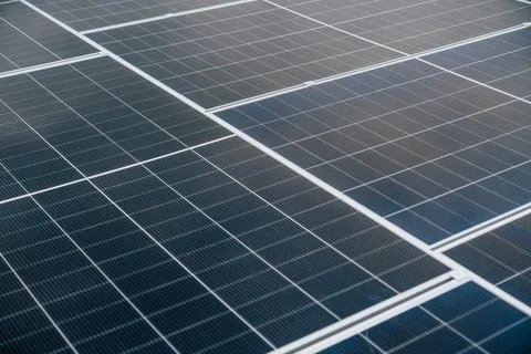 Solar panels installed on a rooftop capture sunlight during the afternoon f.. Stock Photos