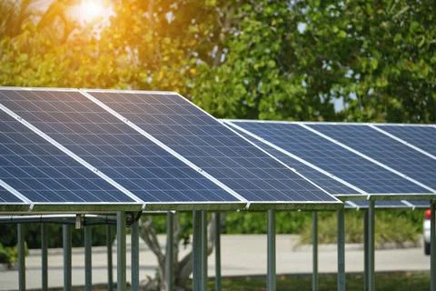 Solar panels installed on stand frame near parking lot for effective generation Stock Photos