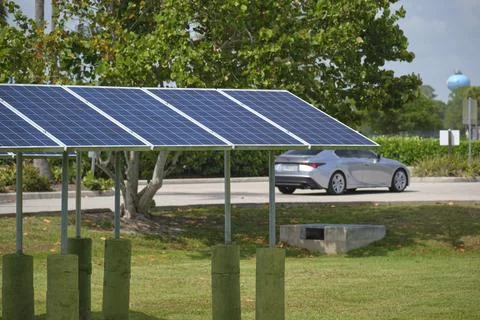 Solar panels installed on stand frame near parking lot for effective generati Stock Photos
