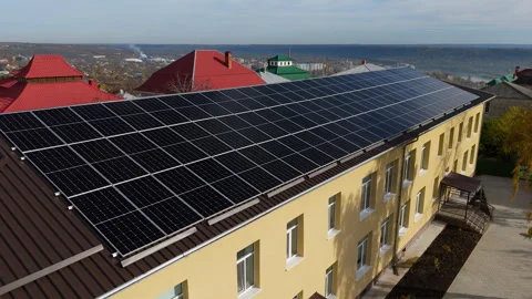 Solar panels installed on a yellow building roof, showcasing renewable energy Video stock 323235529