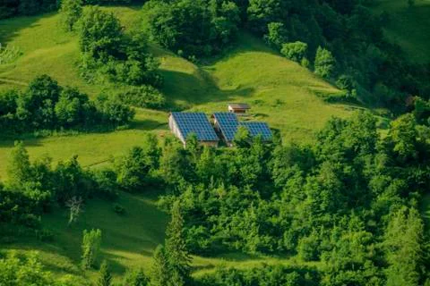 Solar panels mounted on green hill slope. long shoot Stock Photos