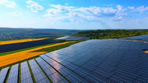 Solar panels overlooking fields beneath scattered clouds, reflective modules Stock Footage 337913052