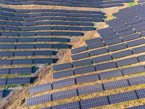 Solar panels placed on a hillside to generate renewable energy in a rural are Stock-Fotos