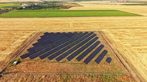 Solar panels placed on a large field in rural area during bright day Stock Footage 340959093