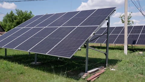 Solar panels positioned on a grassy field, showcasing their sleek design and Stock Footage 319538413