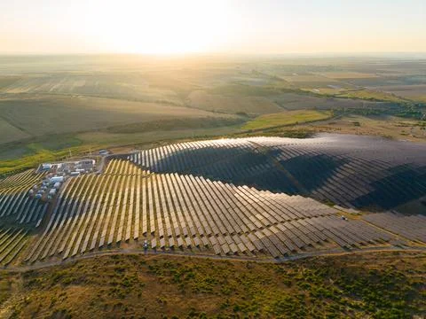 Solar panels reflect sunlight in a renewable energy field on a hillside dur.. Stock-Fotos