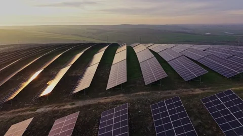 Solar panels on rolling hills during sunset in a green landscape Видео 330002690