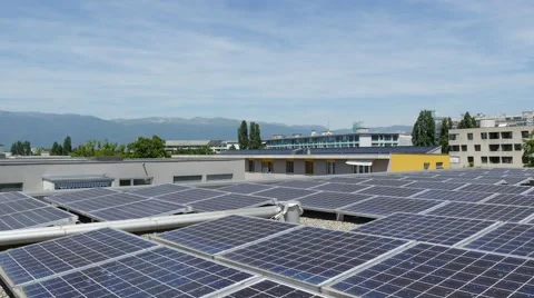 Solar panels on rooftop with city in background 스톡 동영상 68520009