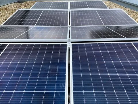 Solar panels on the rooftop of a house, using renewable energy in modern buildin Stock Photos