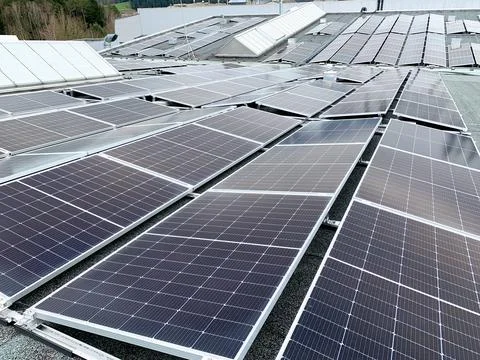 Solar panels on the rooftop of a house, using renewable energy in modern buildin Stock Photos