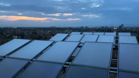 Solar panels on a rooftop in the middle of a city at blue hour. Stock Footage 245569792