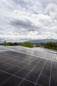 Solar panels in rural landscape with mountains and cloudy sky Fotos de archivo